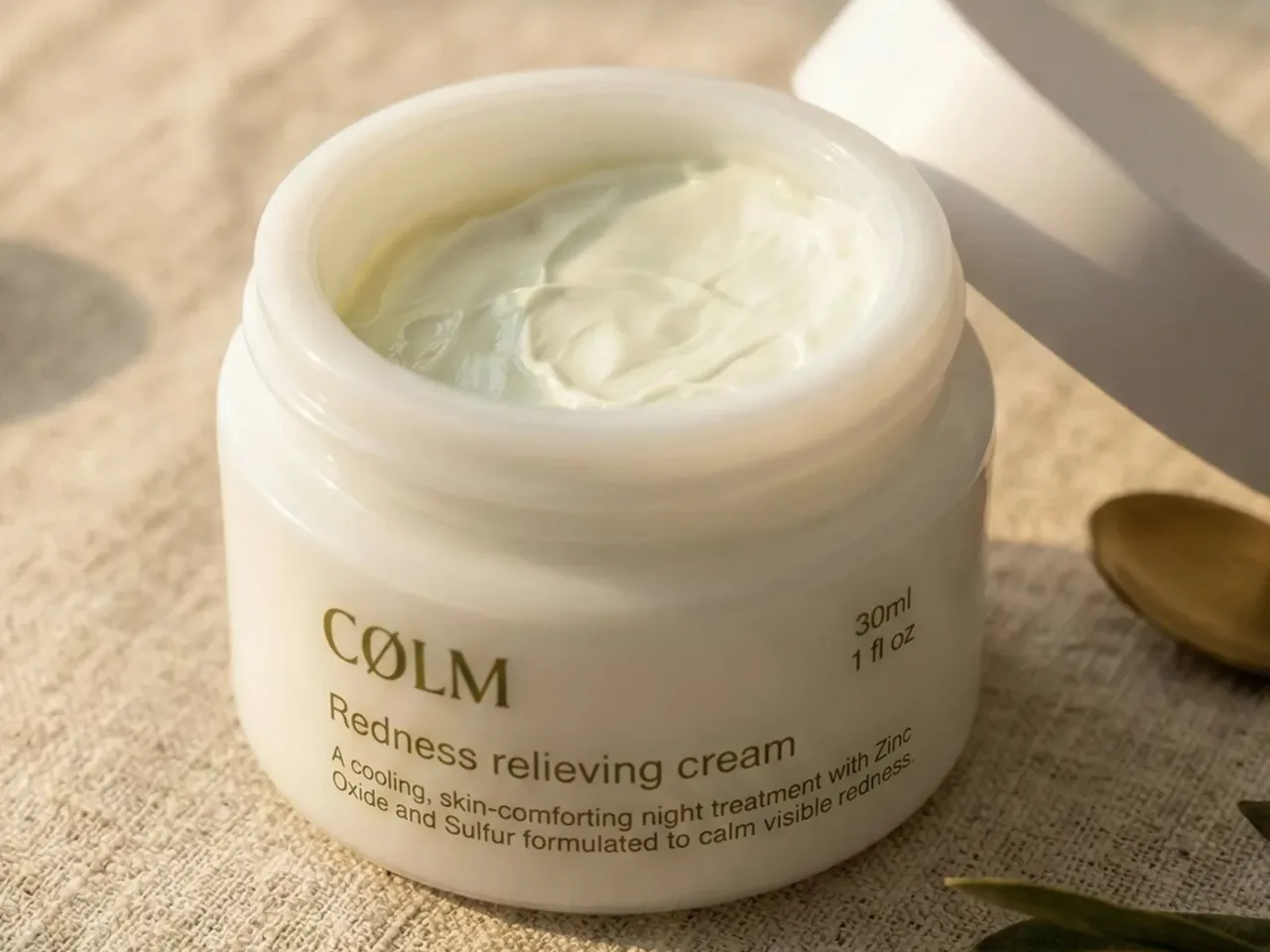 Åben krukke med CØLM Redness Relieving Cream, hvor den lyse, tætte creme er synlig.